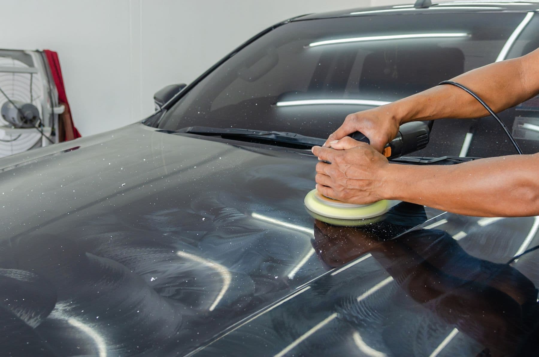 Vehicle paint being machine polished during paint correction
